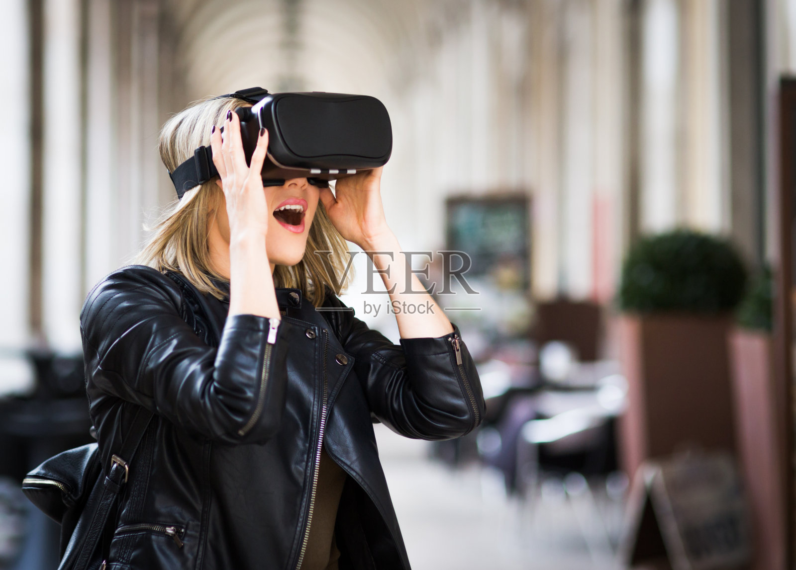 女性在街上测试虚拟现实模拟器照片摄影图片