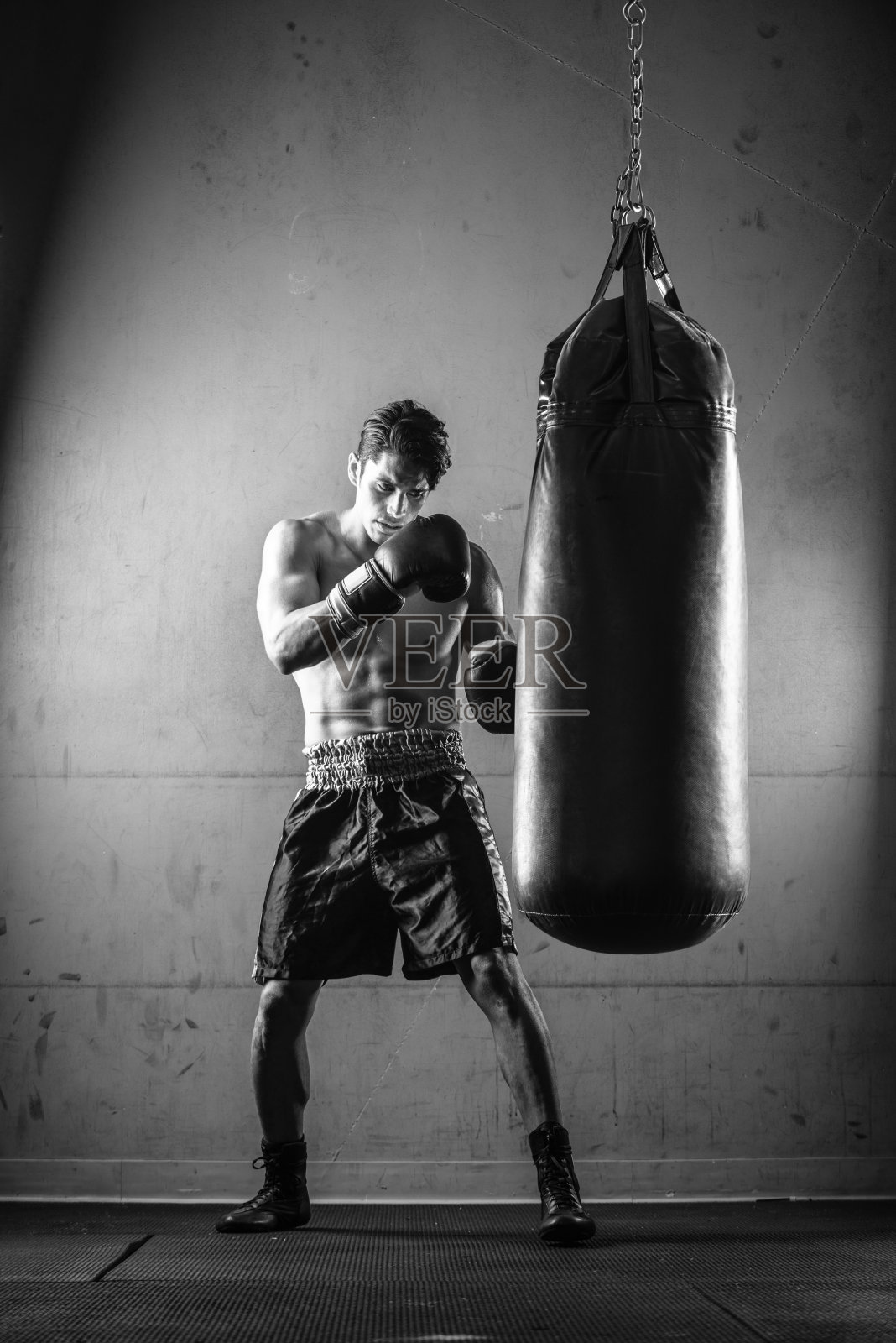 一名西班牙男子在《黑与白》中击打拳击袋照片摄影图片