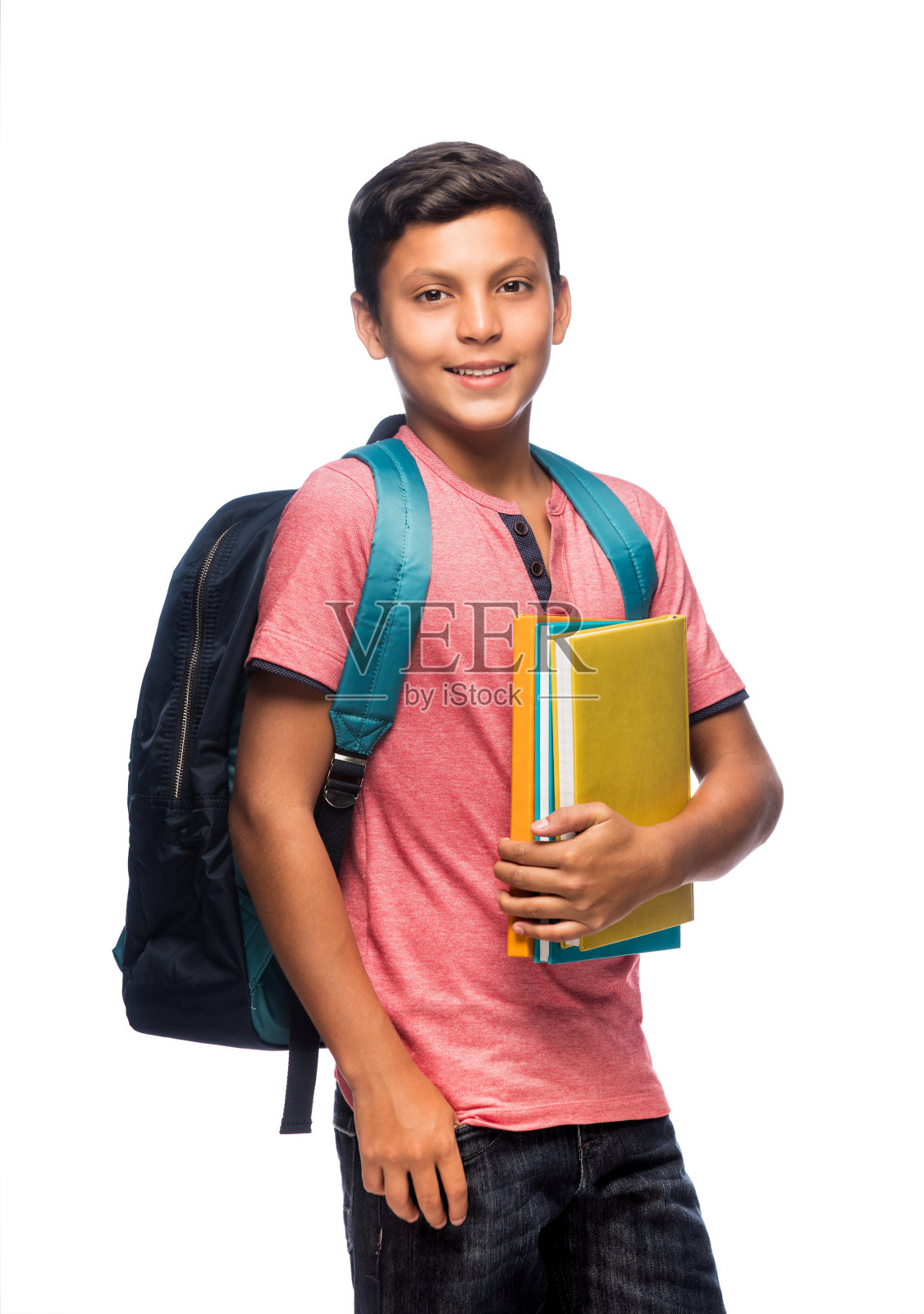 一个十几岁的男生拿着书，面带微笑地站着照片摄影图片