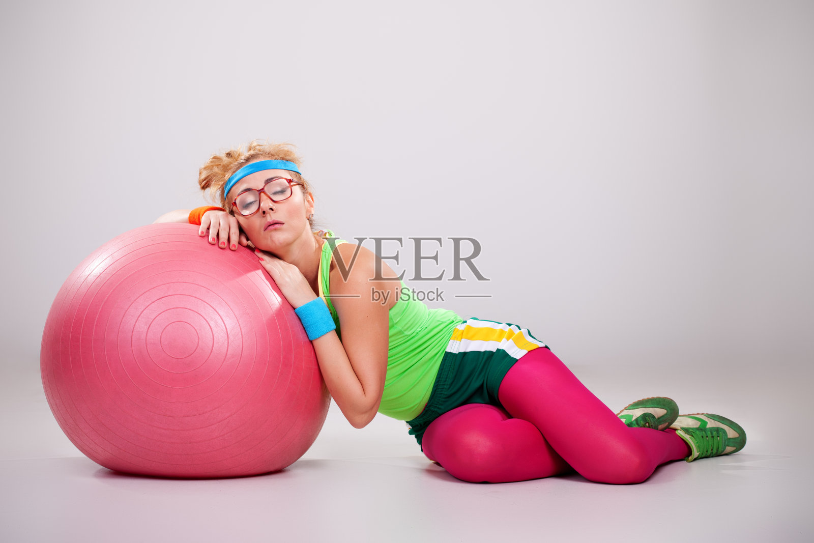 疲惫的健身宅女睡在普拉提球上照片摄影图片