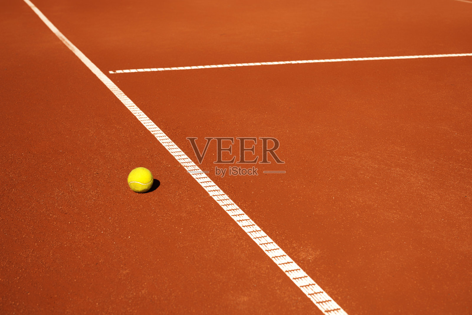 红色红土球场上的黄色网球照片摄影图片