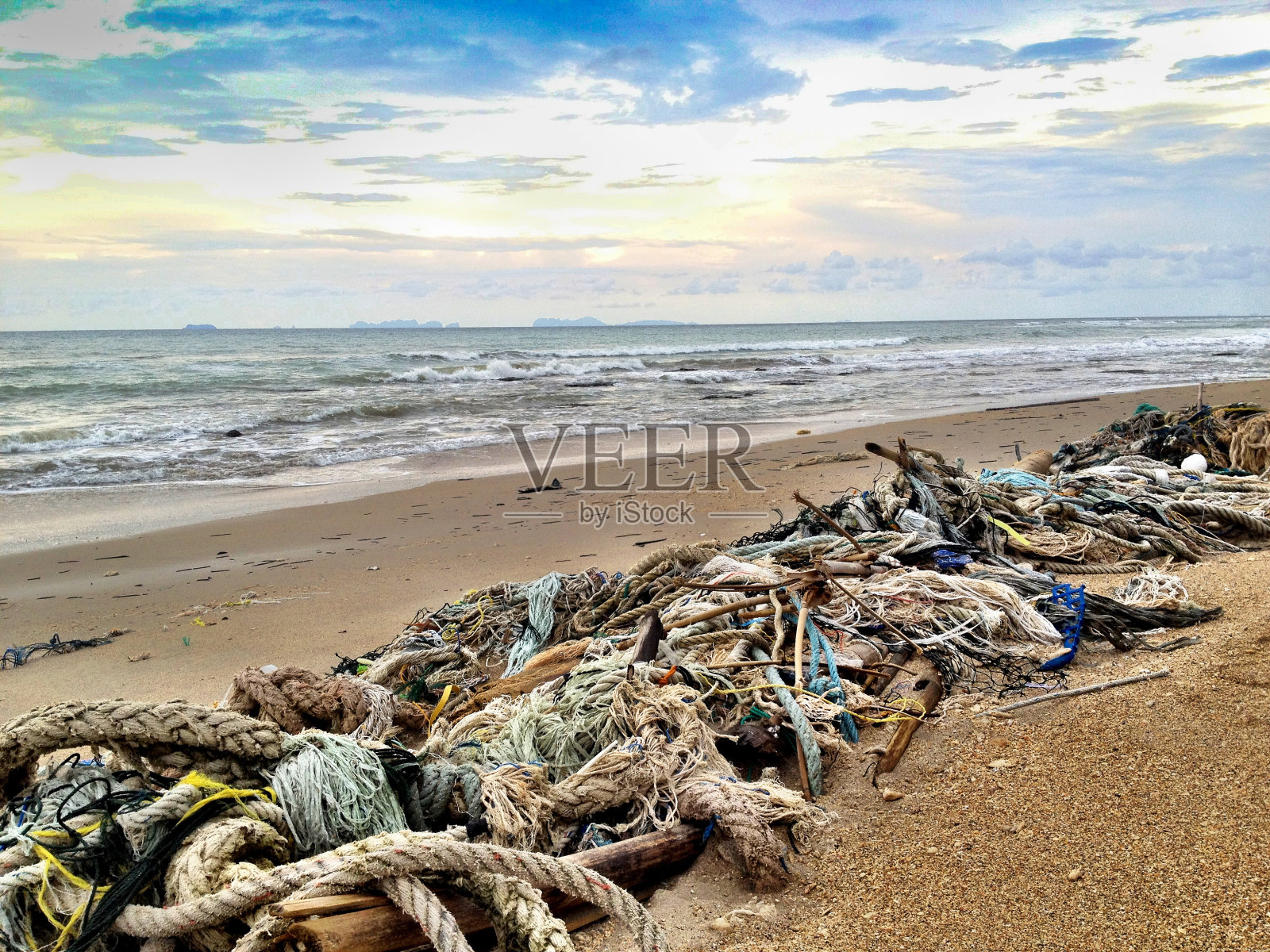 废弃的渔网对海滩环境的破坏照片摄影图片