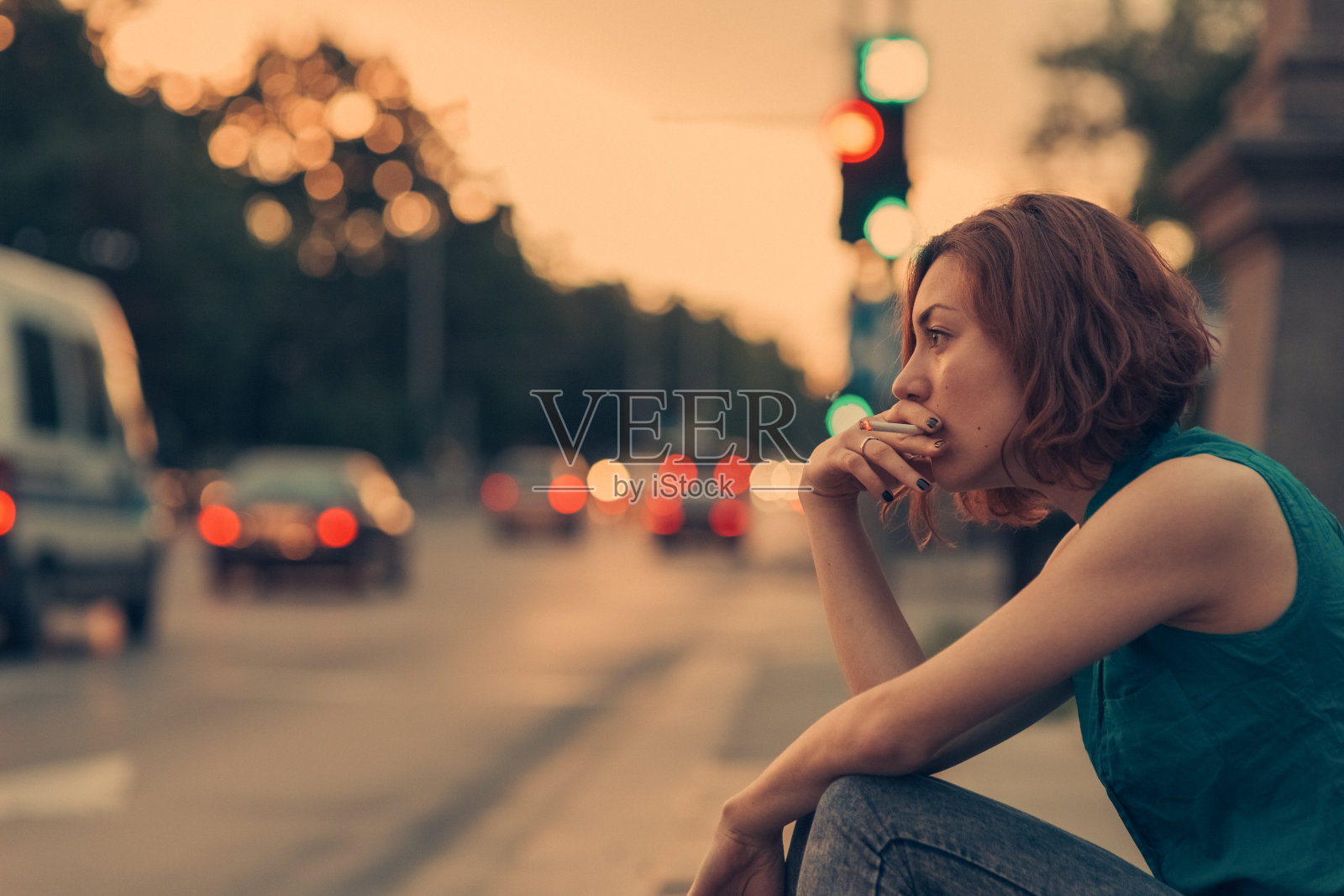 沮丧的年轻女子在街上抽烟照片摄影图片