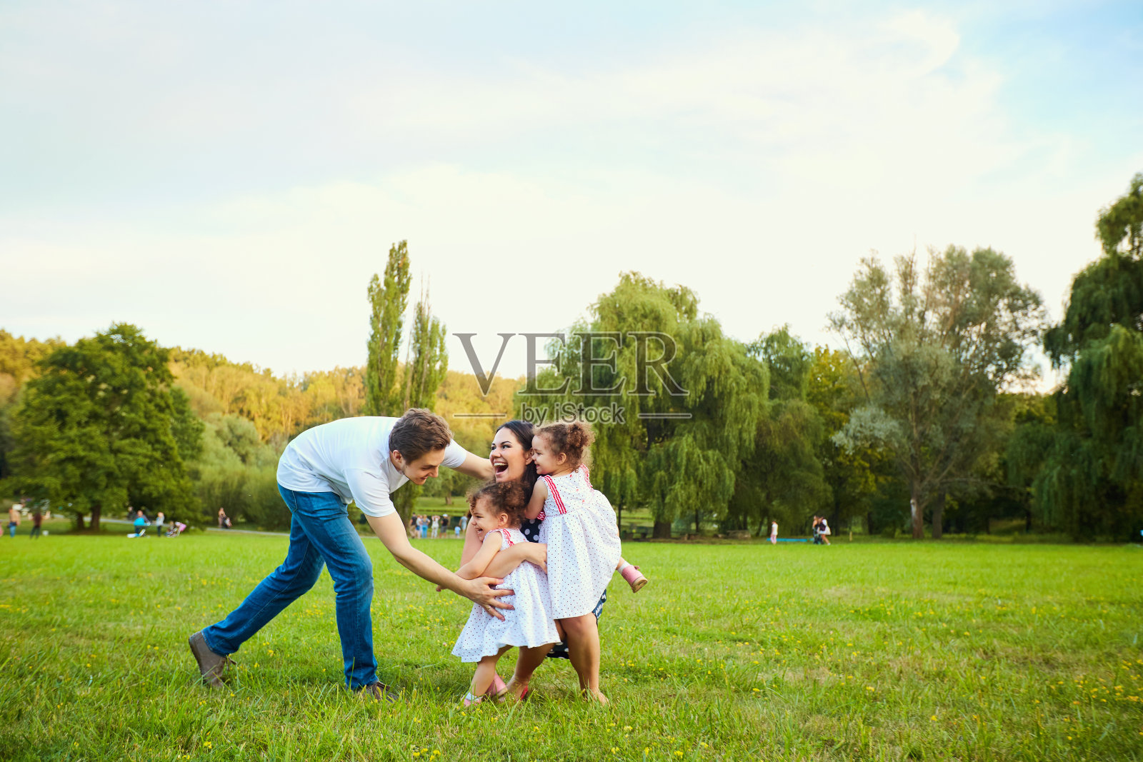 快乐的家庭和孩子们在公园里玩耍照片摄影图片