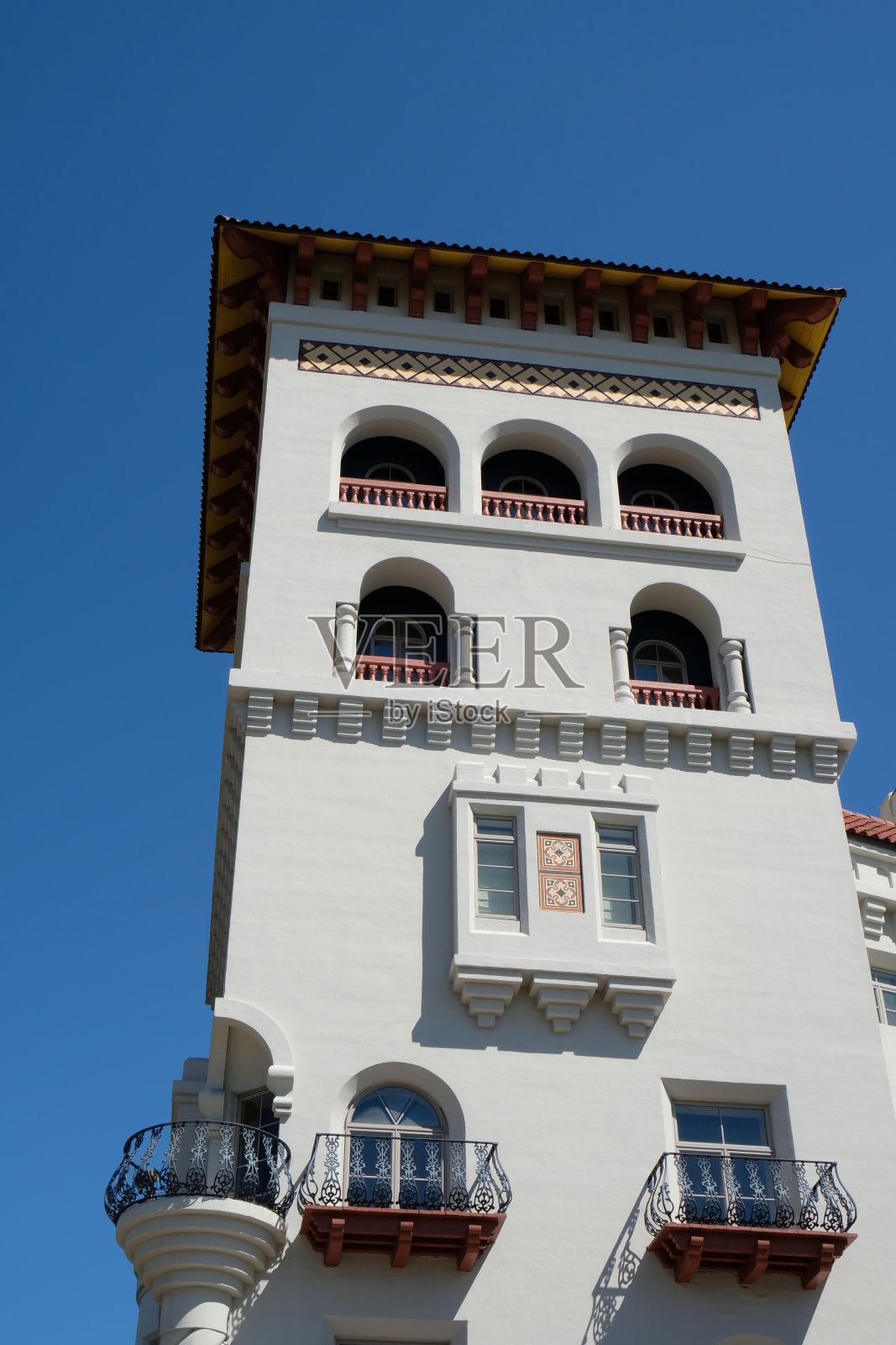 在佛罗里达圣奥古斯丁，一个历史建筑的塔顶上，有摩尔复兴风格和西班牙巴洛克复兴风格。蓝色,万里无云的天空。照片摄影图片