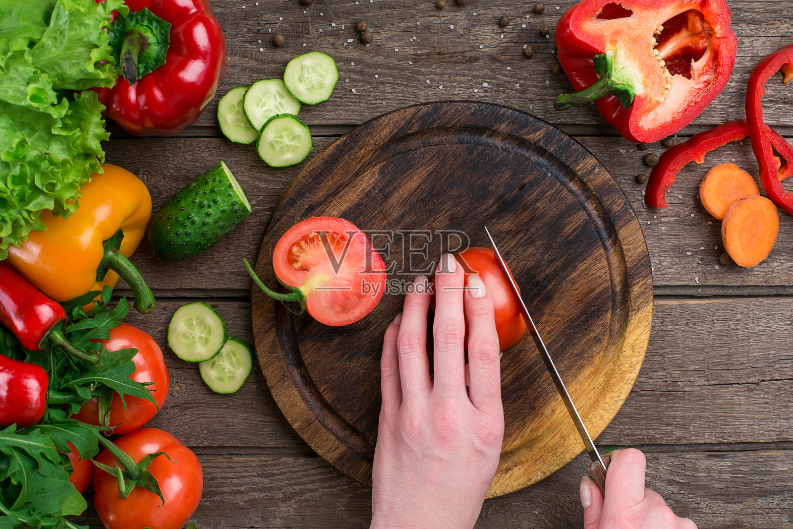 女人的手在桌子上切西红柿，俯视图照片摄影图片