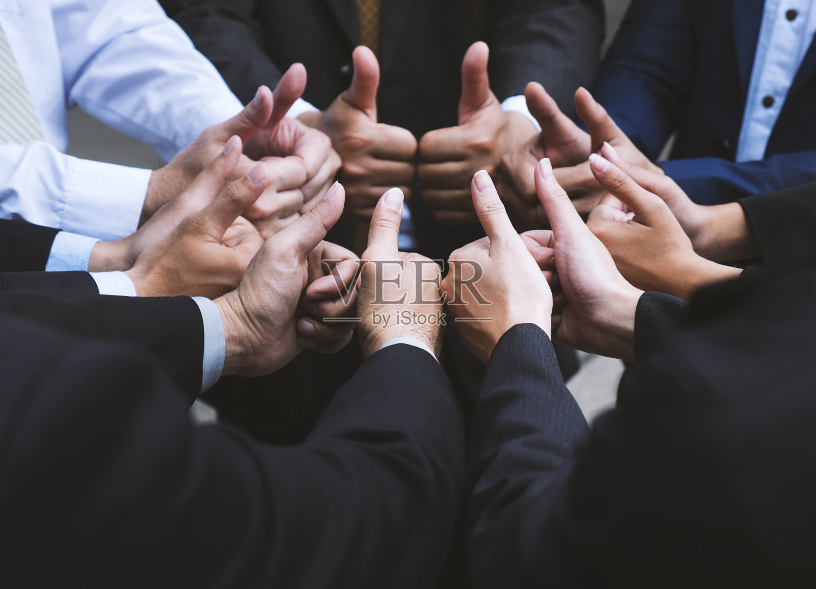 商业人士在一起竖起许多大拇指，显示团队合作的力量。欢呼与成功的理念。照片摄影图片