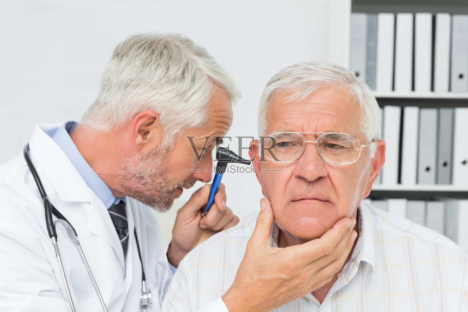 一个男性医生检查老年病人的耳朵的特写照片摄影图片