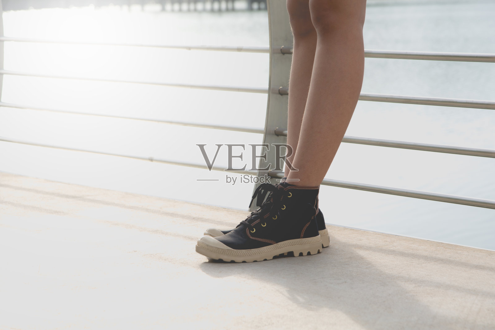一位年轻的女士站着。站立式女式运动鞋。照片摄影图片