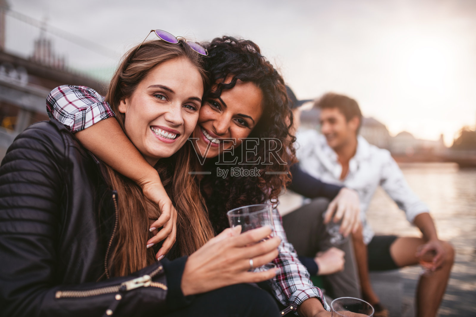 快乐的女性朋友在湖上玩饮料照片摄影图片