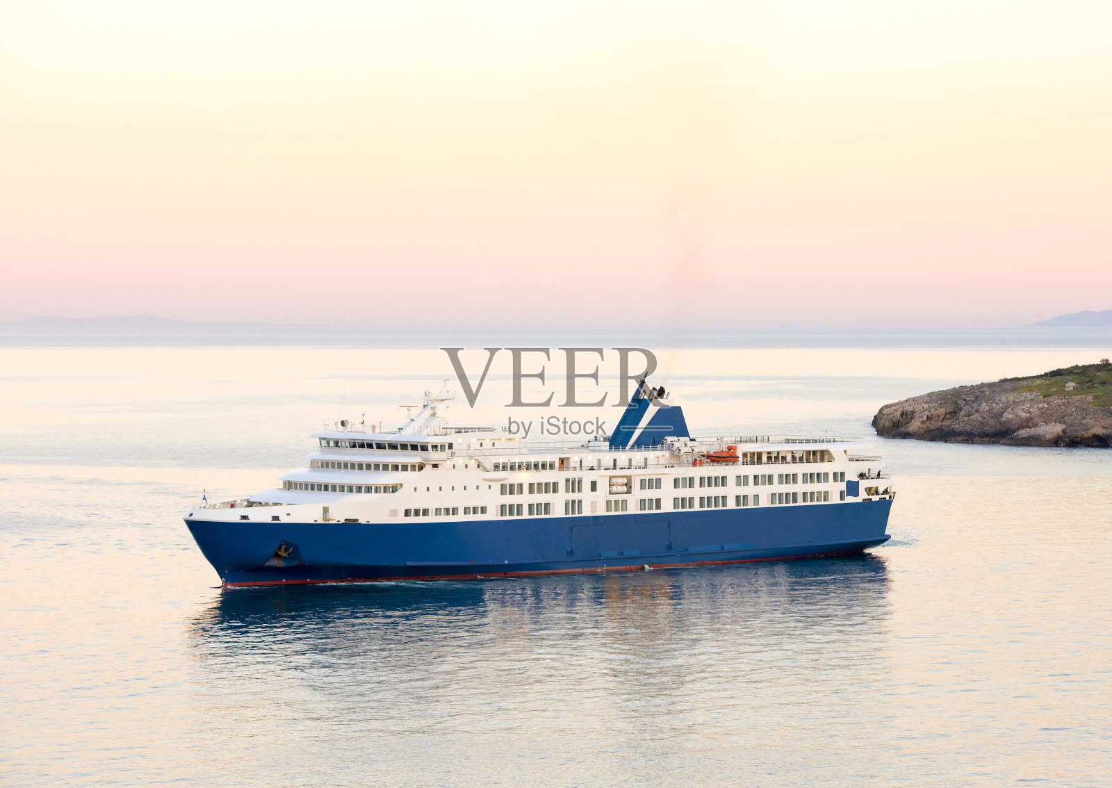 夕阳和希腊群岛上的蓝白渡船照片摄影图片