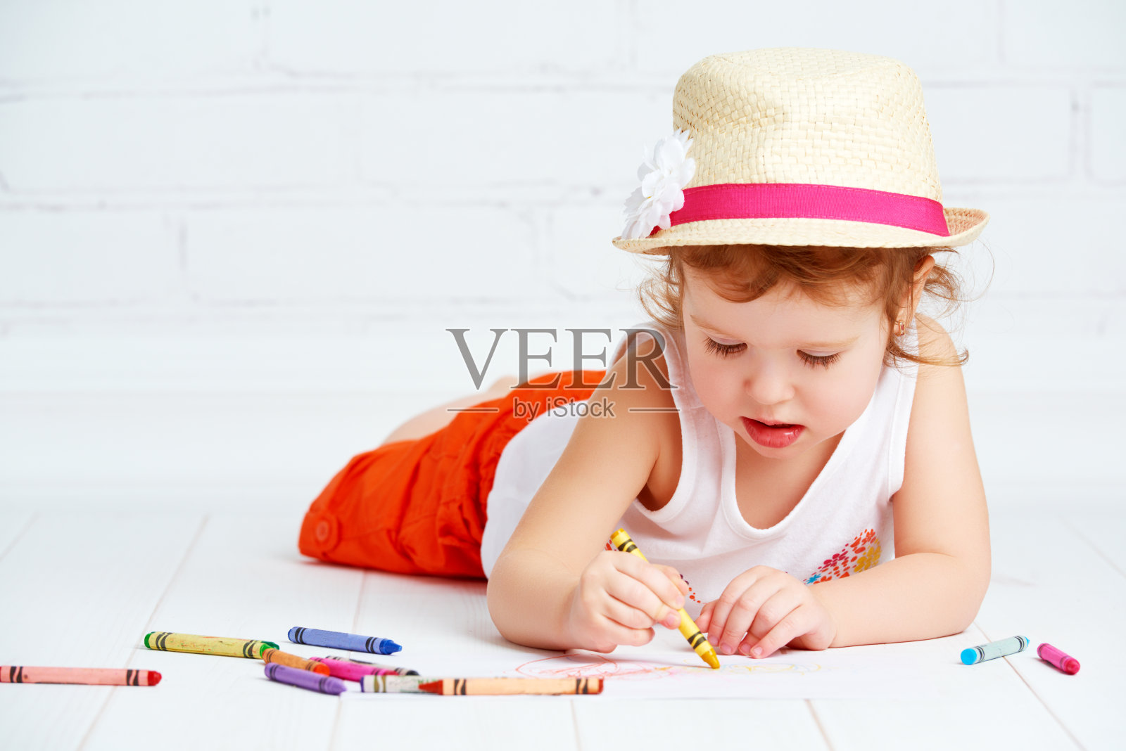 快乐的小艺术家女孩戴着帽子画铅笔照片摄影图片