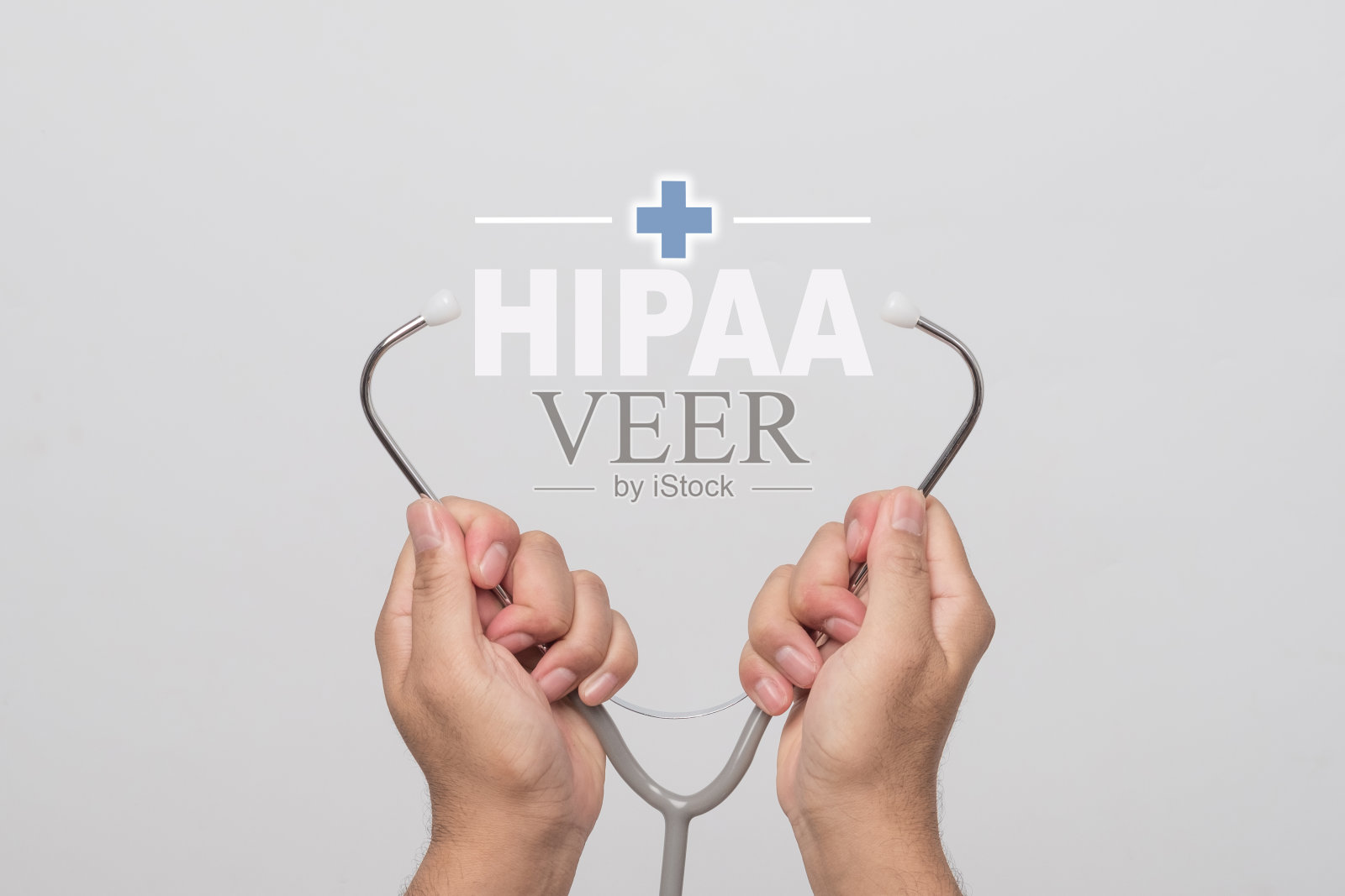 双手拿着听诊器，灰色背景上写着“HIPAA”。健康的概念。照片摄影图片