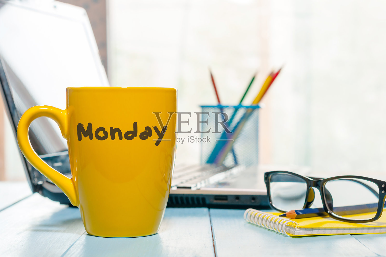 星期一写在黄色咖啡杯或茶杯上的木板桌子上，工作场所，办公室阳光早晨的背景照片摄影图片