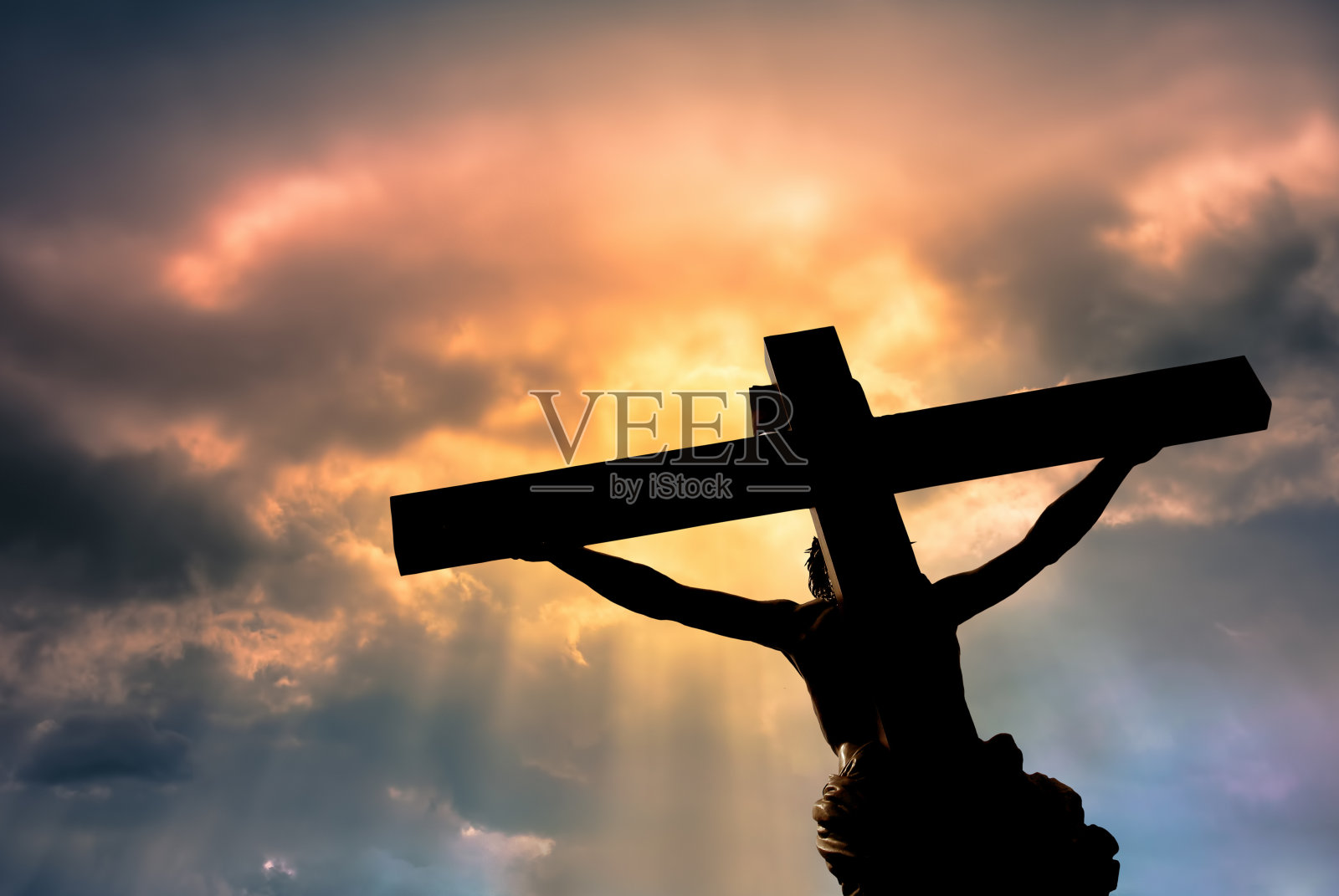 基督教十字架与耶稣基督雕像在暴风雨的云照片摄影图片
