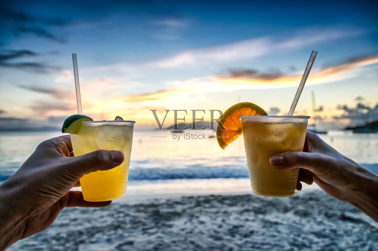 日落时分在海滩上喝玛格丽塔鸡尾酒照片摄影图片