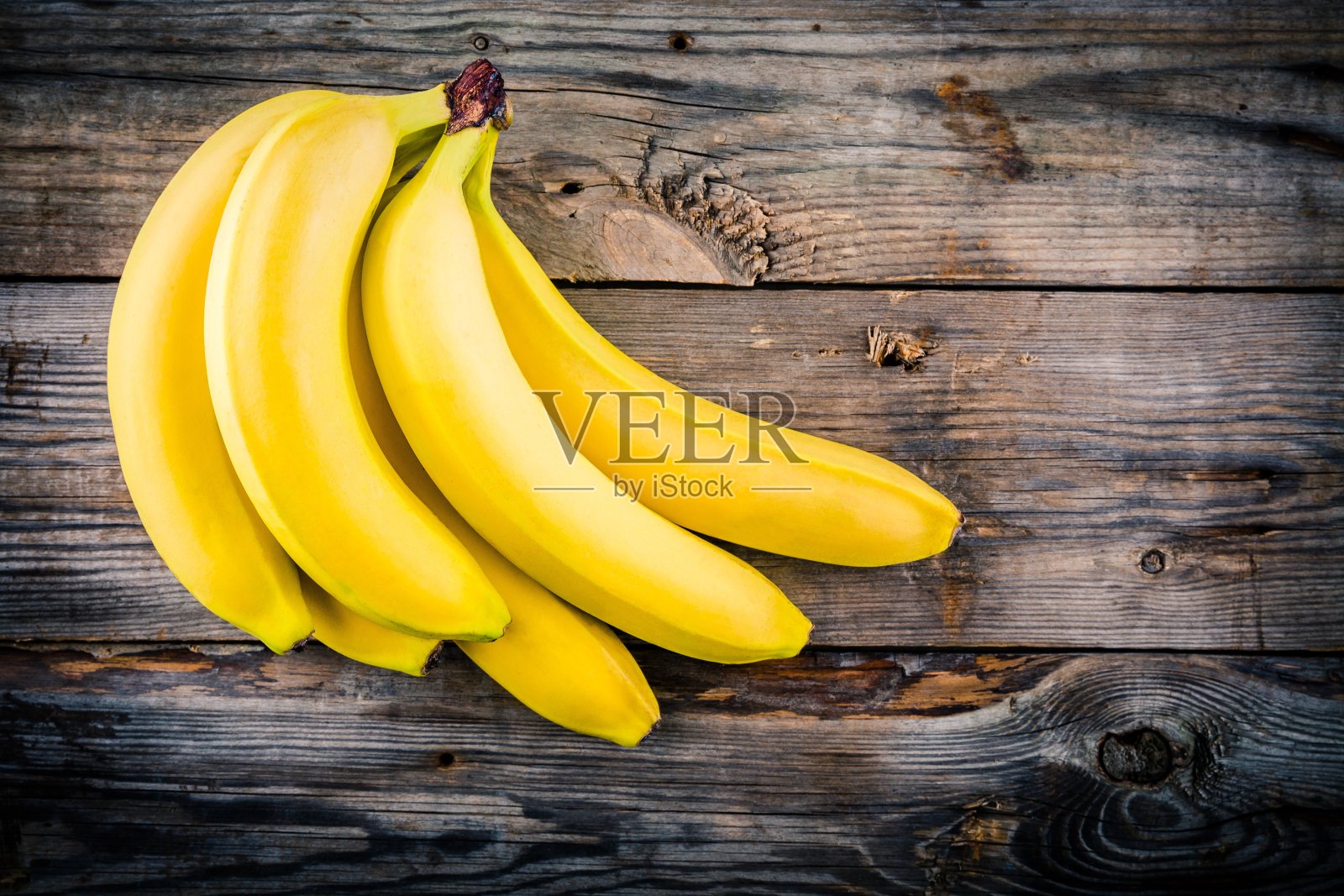 一串生的有机香蕉在木头背景上照片摄影图片