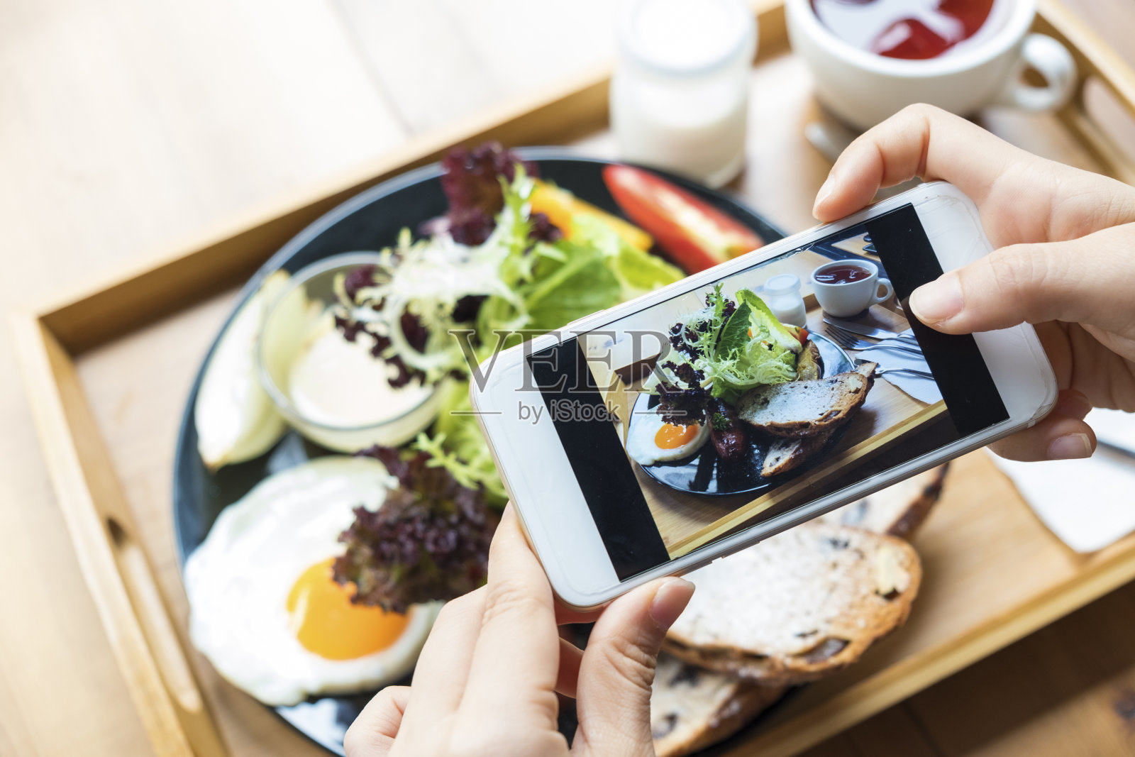 特写手握手机拍摄食物照片照片摄影图片