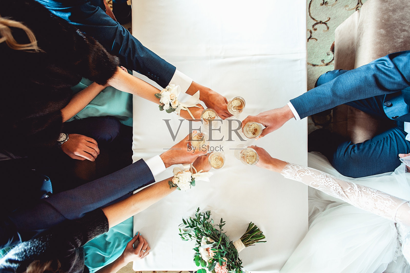 人们手里拿着盛着白葡萄酒的玻璃杯。婚礼。照片摄影图片