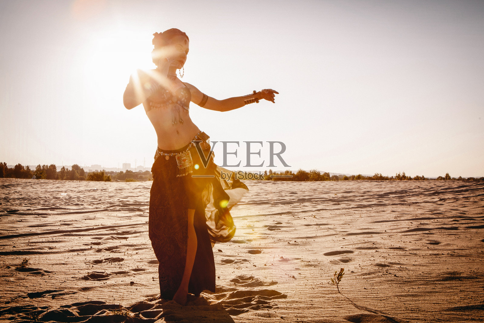 美丽的女孩在沙漠中跳民族舞蹈照片摄影图片