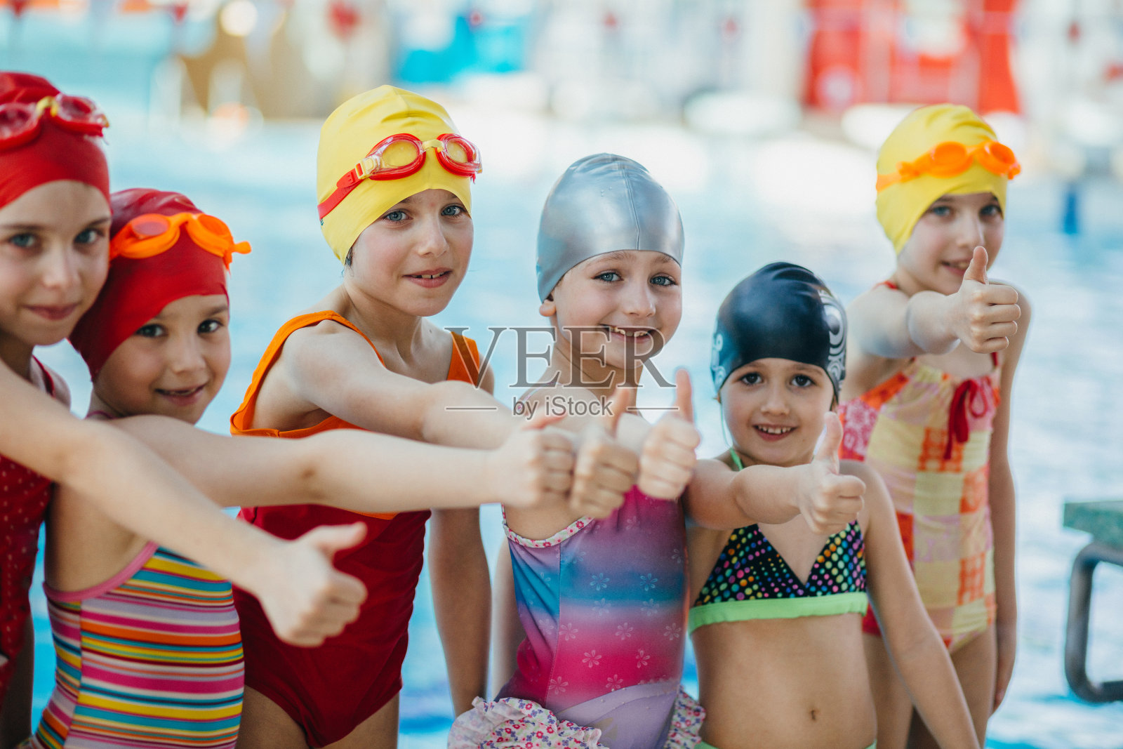 教练和一群孩子在游泳池附近做运动照片摄影图片
