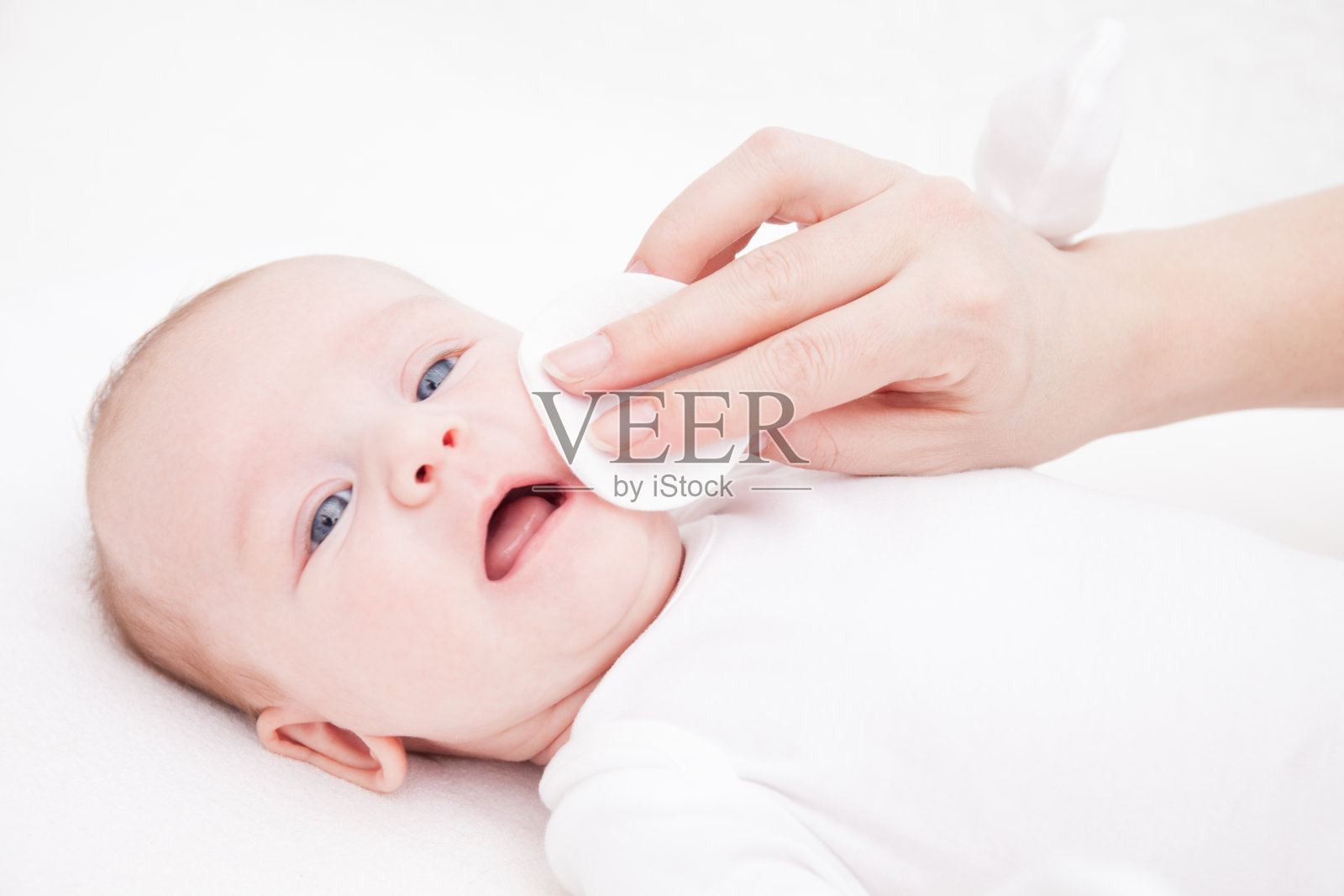 母亲用棉垫为新生儿洗脸照片摄影图片