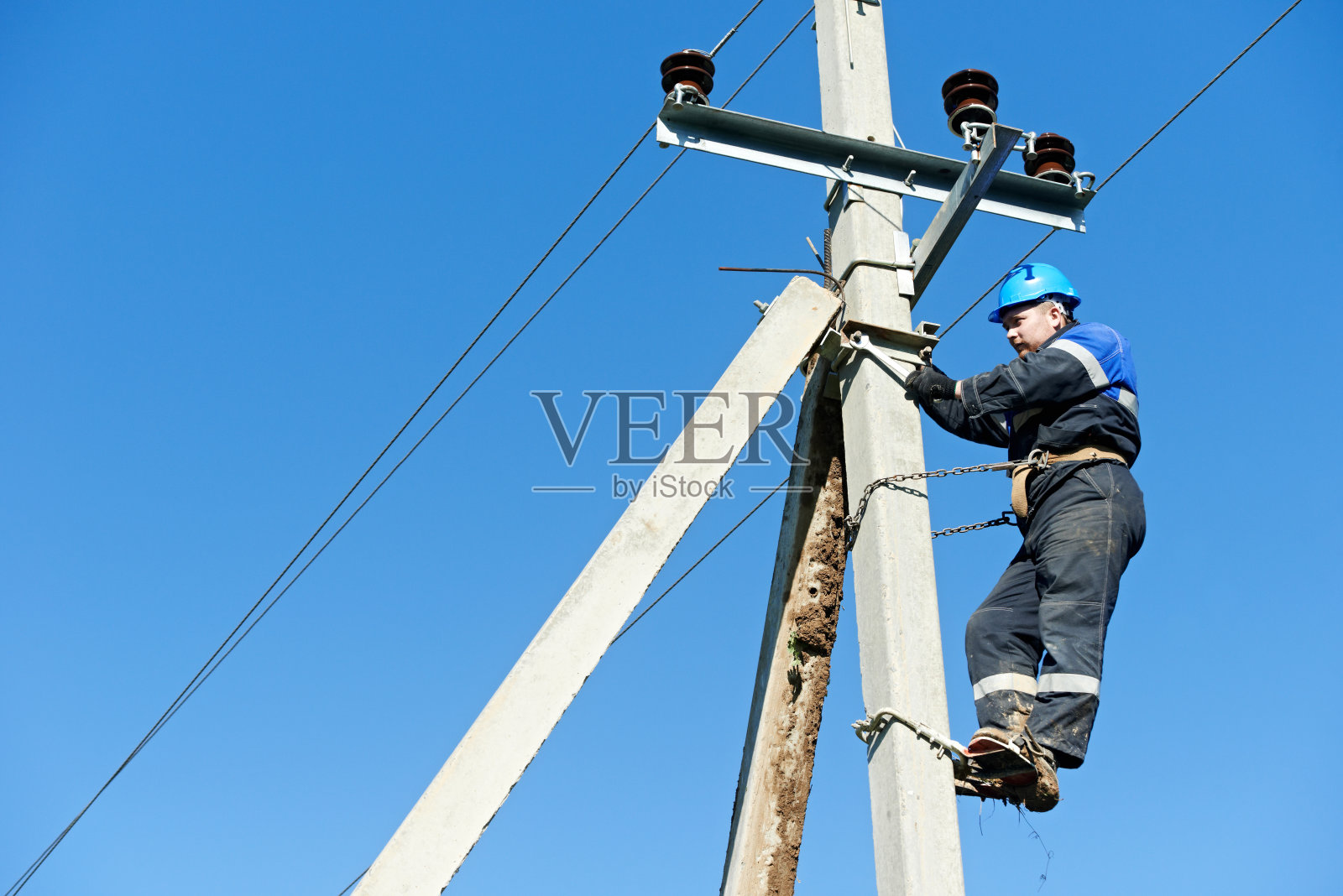 电线工人在电线杆顶端工作照片摄影图片