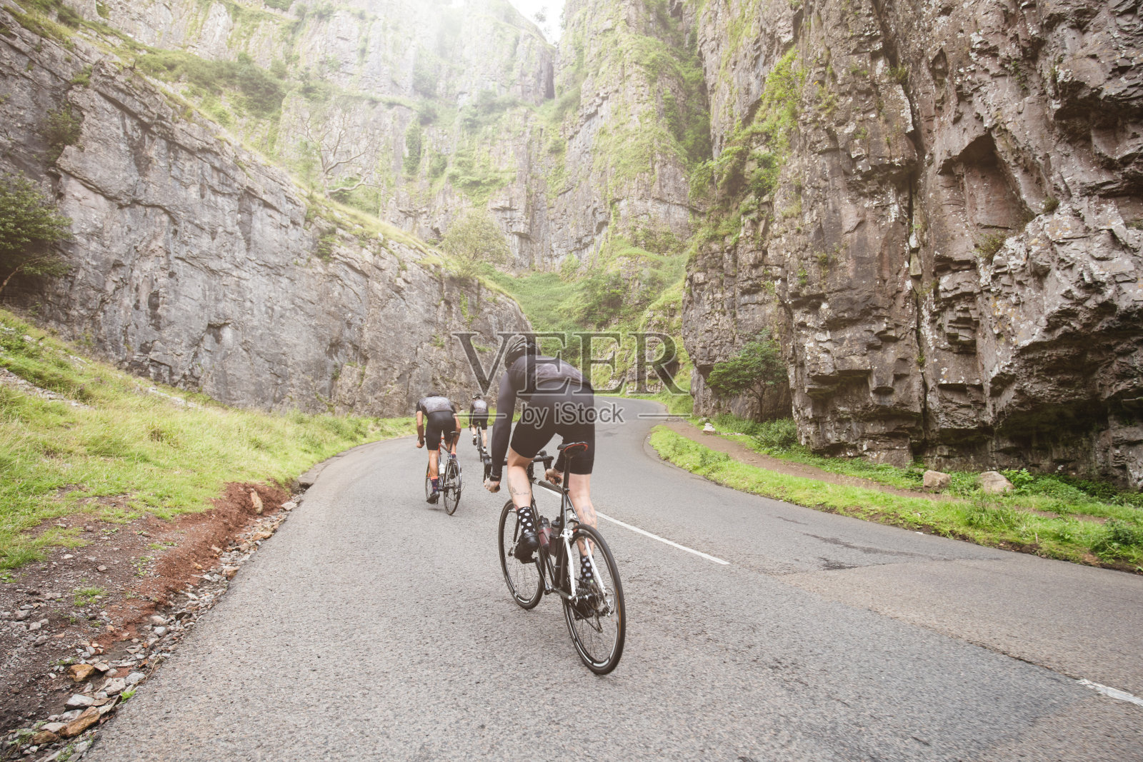 三名骑自行车的人袭击了英国切达峡谷的攀登照片摄影图片
