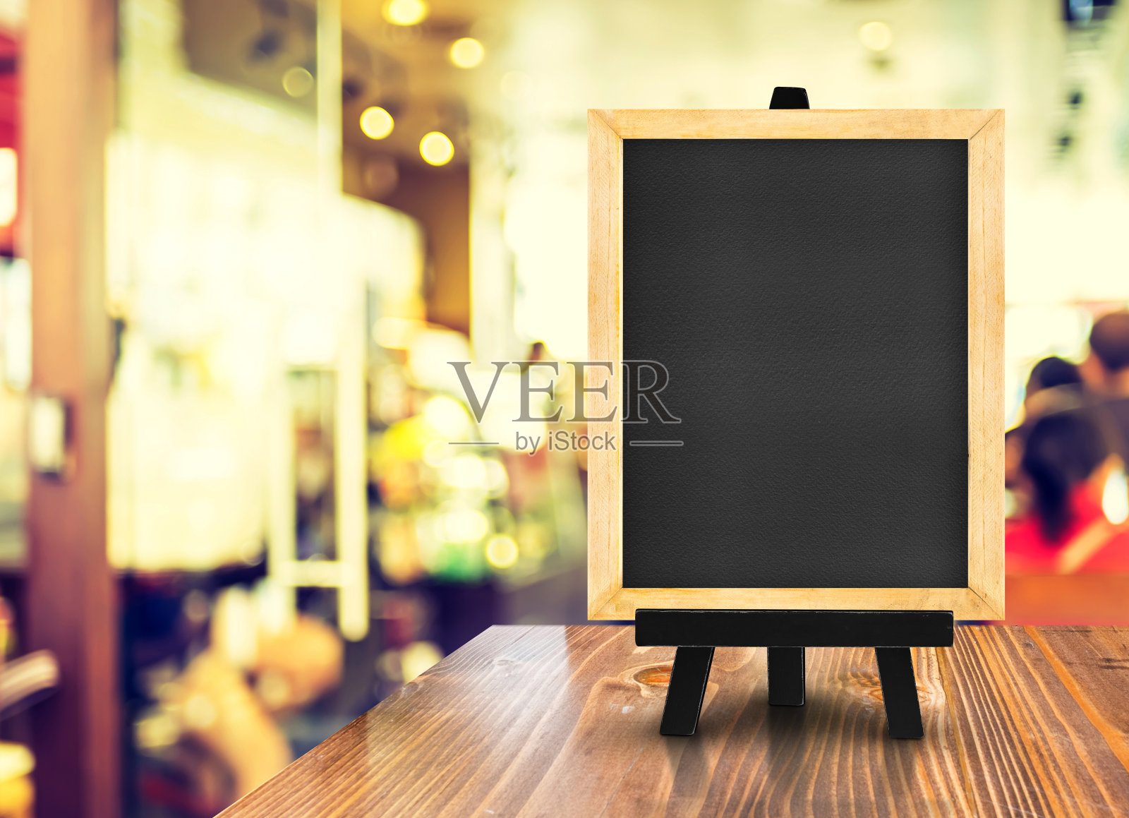 模糊的咖啡店背景木桌上的带有画架的黑板，模拟展示或蒙太奇设计用于网上购物促销照片摄影图片