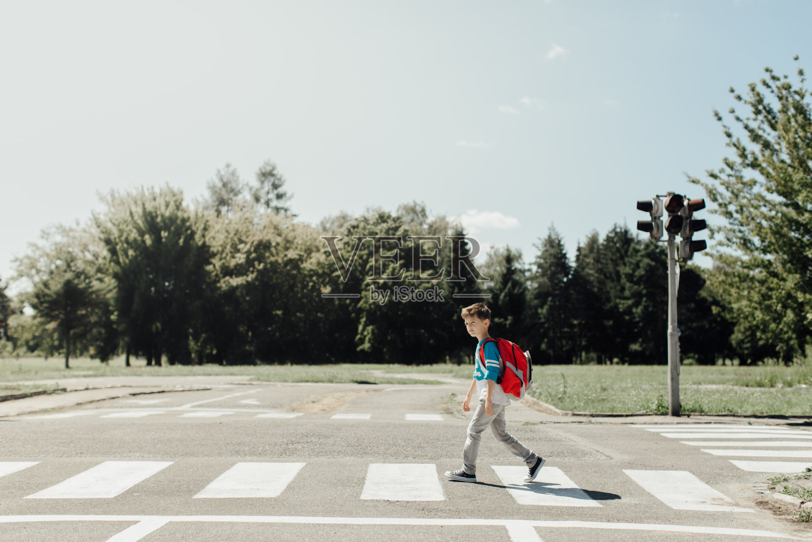 一个男孩在早晨去学校的路上过马路照片摄影图片