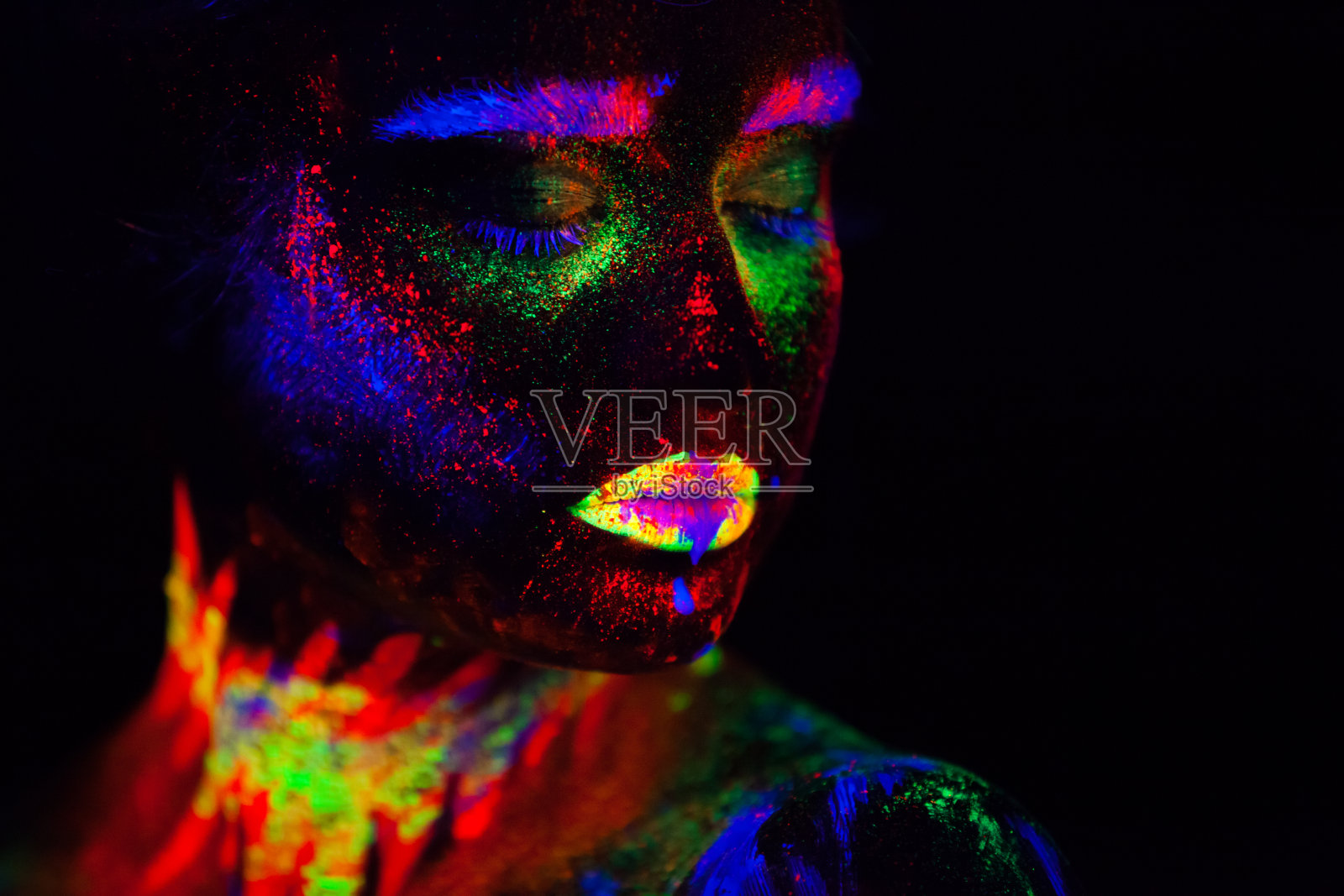 霓虹灯下美丽的外星模特。这是美丽的模特用荧光化妆的肖像，女性在UV中摆姿势的艺术设计，彩色的化妆。孤立在黑色背景上照片摄影图片
