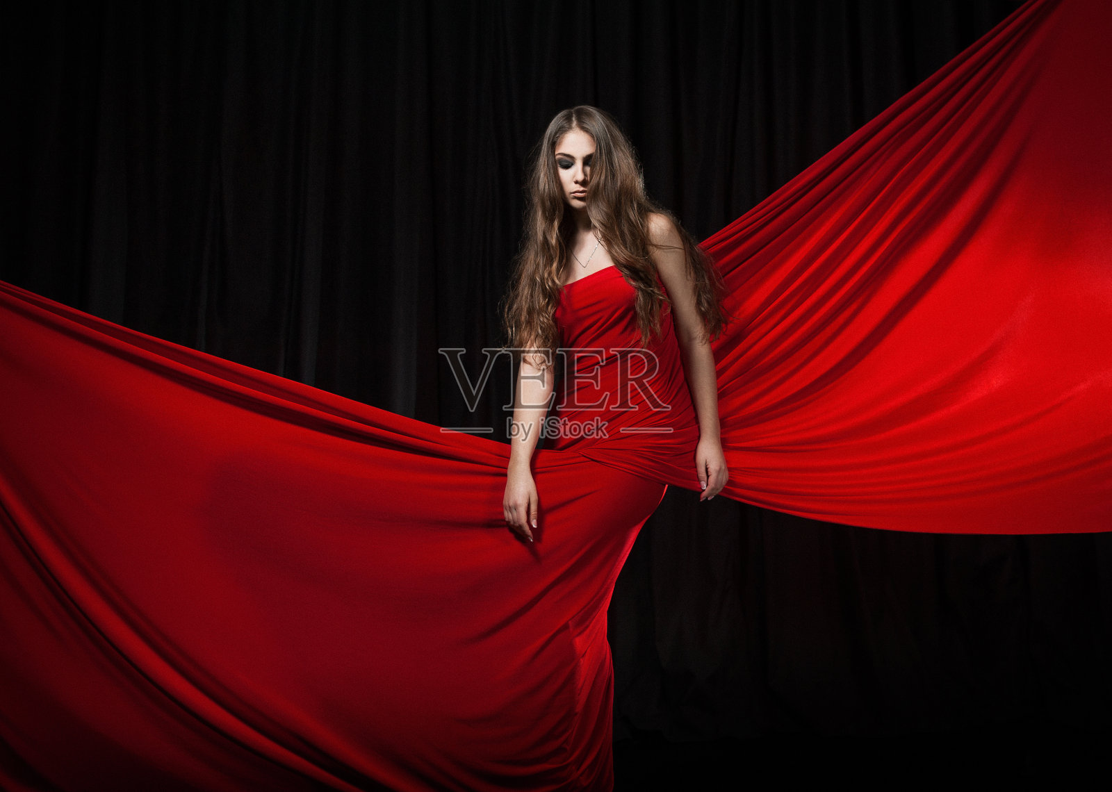 美丽的时装模特跳舞红色连衣裙，红色优雅的丝绸长袍飘扬的面料照片摄影图片