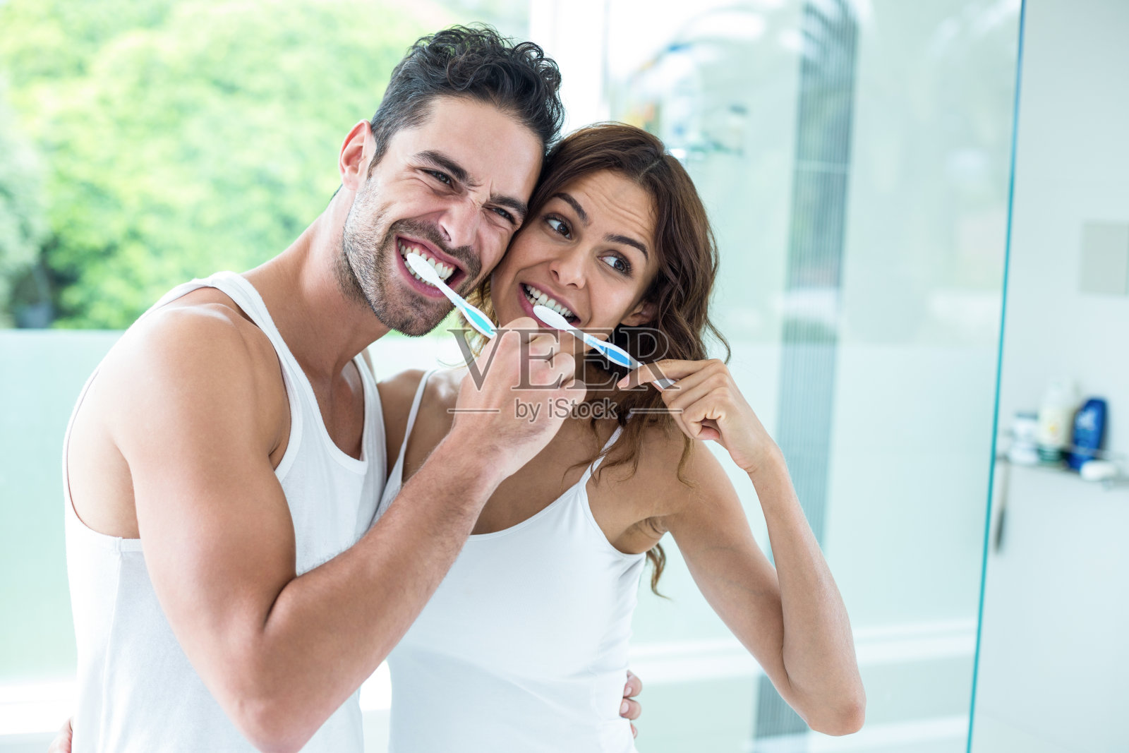 一对年轻夫妇站在浴室刷牙照片摄影图片