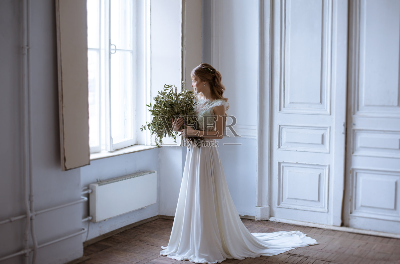 美丽的新娘穿着新娘礼服和花束在室内照片摄影图片