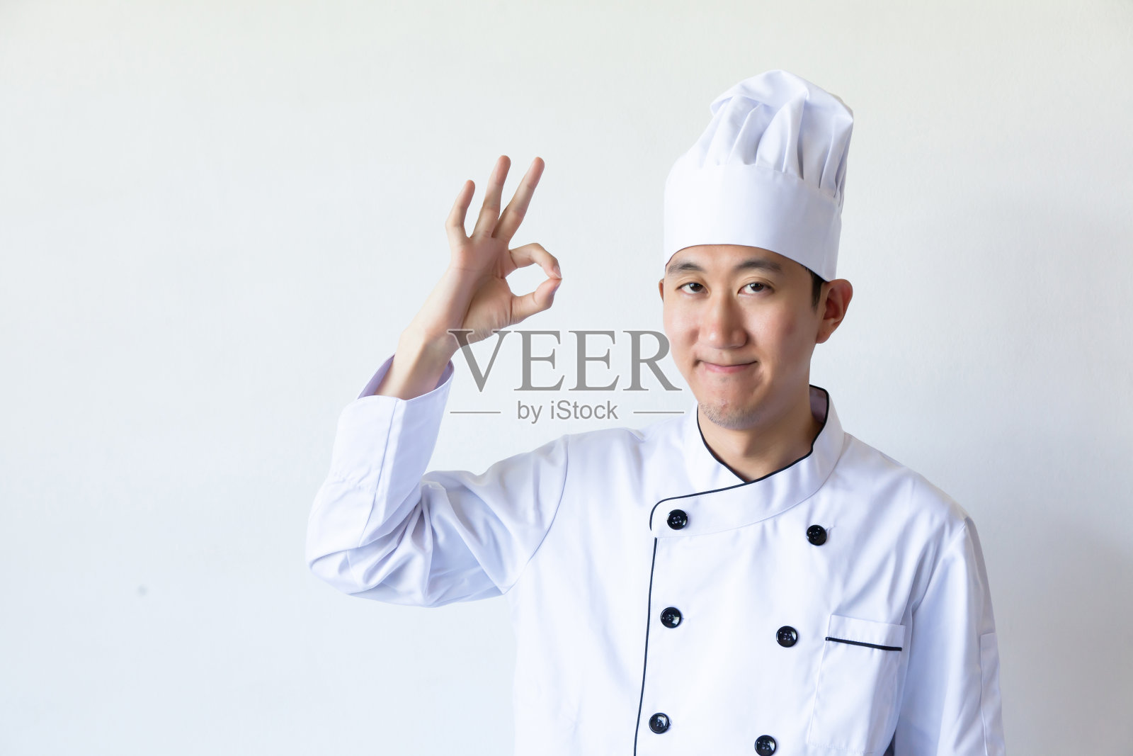 亚洲厨师在白色背景下显示ok标志照片摄影图片