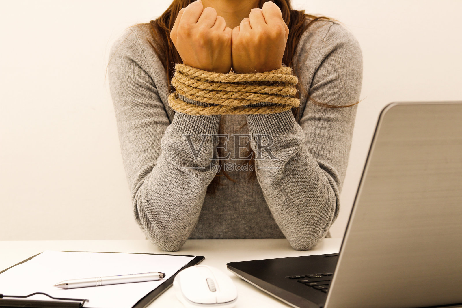 办公室里一个双手被绳子绑着的女人照片摄影图片
