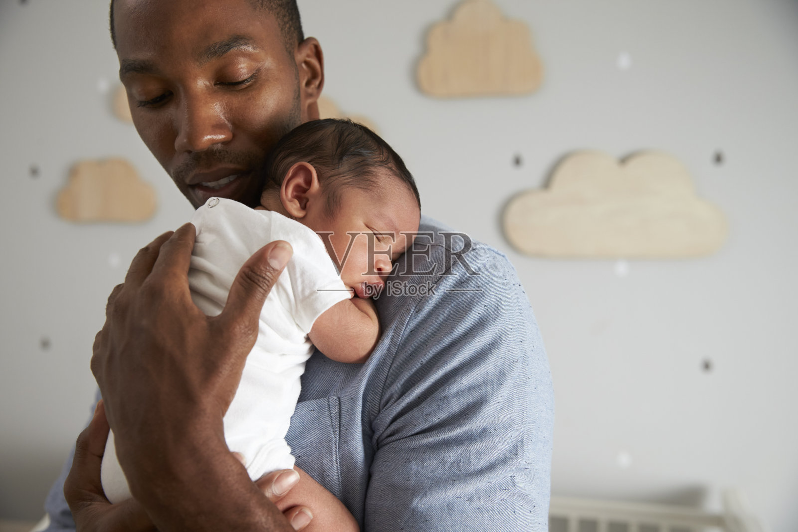父亲抱着刚出生的儿子在托儿所照片摄影图片