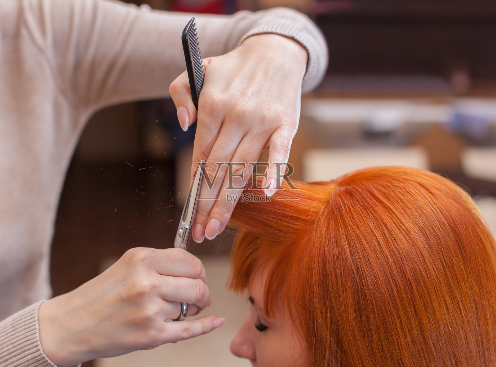 美发师用剪刀给一个红发姑娘理发照片摄影图片
