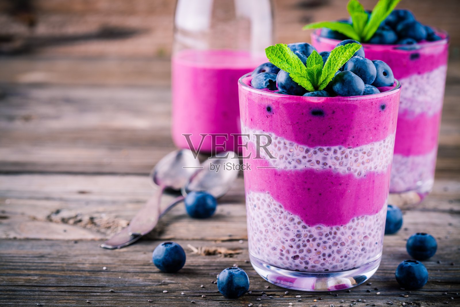 蓝莓冰沙与奇亚布丁玻璃杯与新鲜浆果和薄荷照片摄影图片