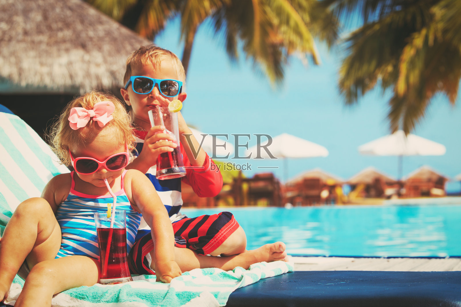 孩子们在热带海滩度假胜地放松和喝果汁照片摄影图片