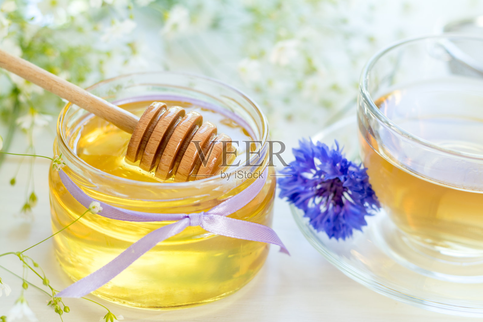 蜂蜜在玻璃罐和一杯茶照片摄影图片