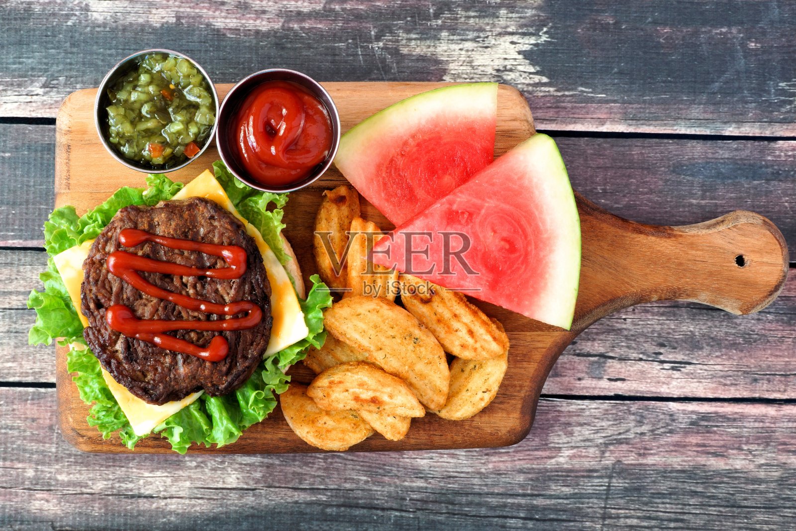 野餐场景，汉堡，土豆和西瓜在桨板上照片摄影图片