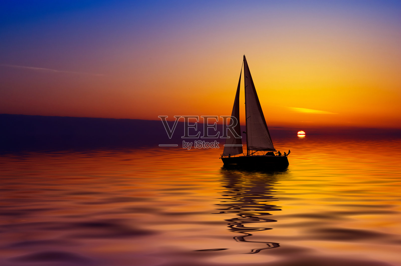 帆船在平静的水面上，在缤纷的日落照片摄影图片