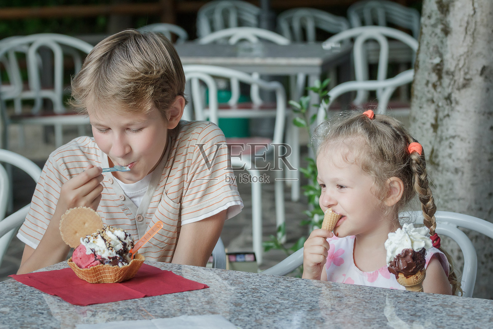 两个兄弟姐妹在意大利冰淇淋店吃甜点照片摄影图片