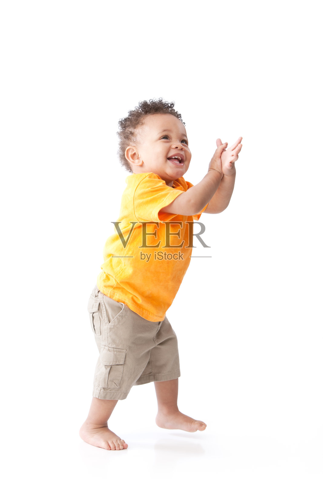 真人版:黑色笑着蹒跚学步的小男孩橙色站着鼓掌照片摄影图片