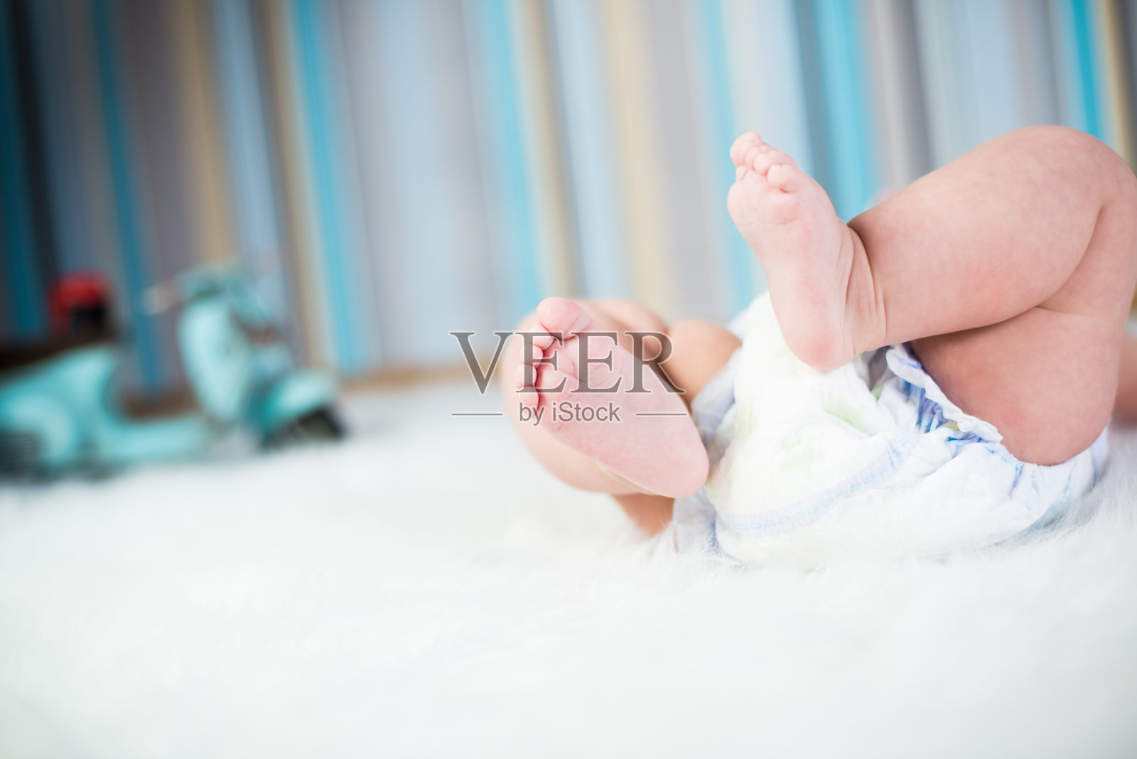 刚出生的婴儿穿着尿布躺在毛绒毯子上照片摄影图片