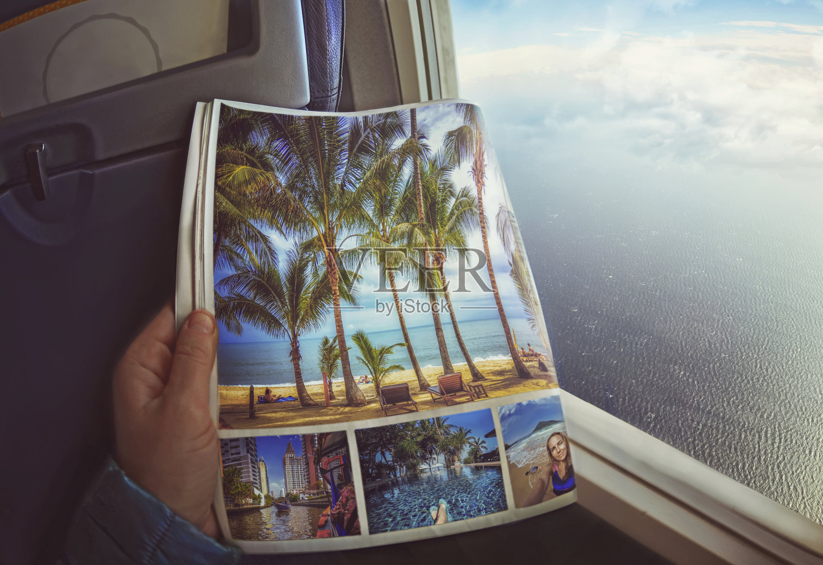 一个女人坐在飞机的窗口，手里拿着杂志照片摄影图片