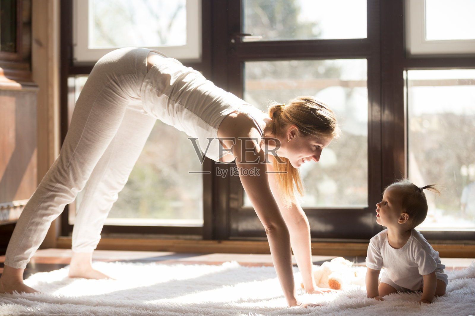 年轻的瑜伽母亲和女婴坐在旁边，健康的一天照片摄影图片