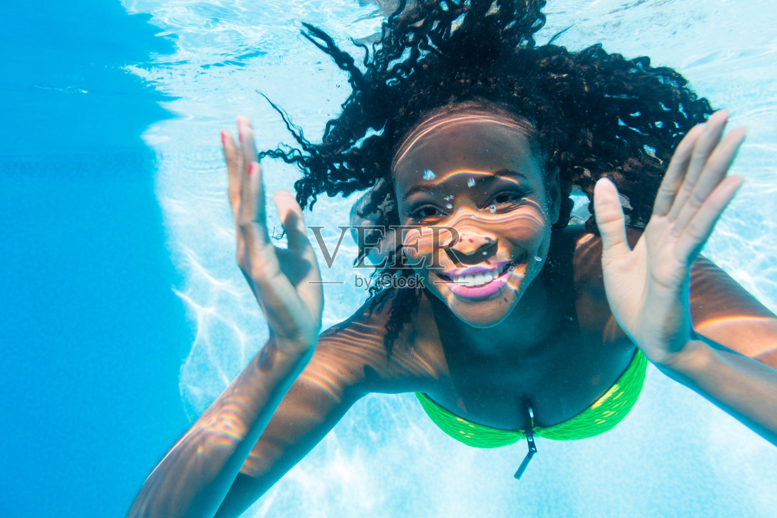 度假的黑人女孩在游泳池跳水照片摄影图片