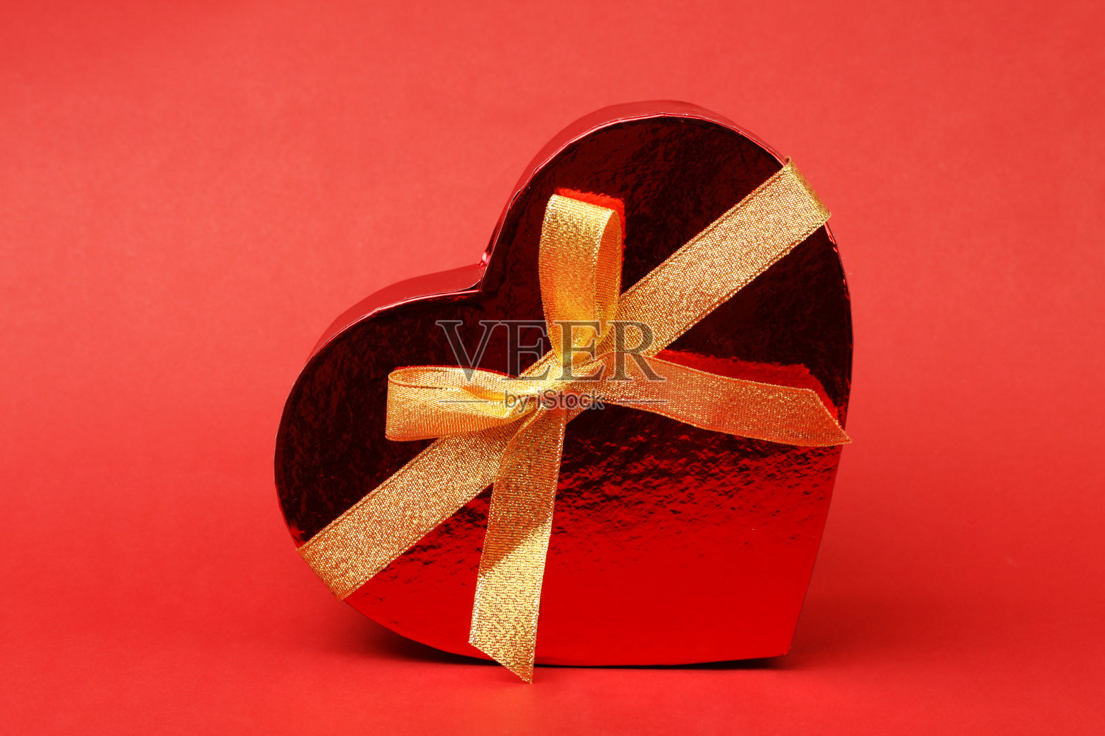 心形盒子，红色背景上有蝴蝶结照片摄影图片